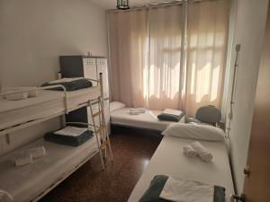 a room with three bunk beds and a window at Albergue La Corona1 in O Pino 