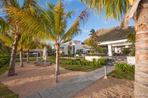 a view of the resort from the beach with palm trees at Latitude - with private plunge pool in Rivière Noire