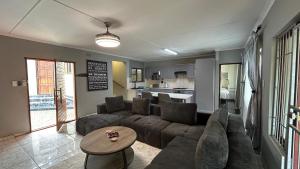 a living room with a couch and a table at TinasRose in Uvongo Beach