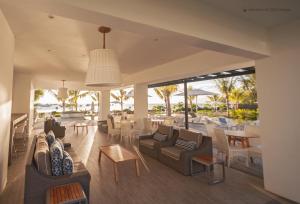 a living room with couches and chairs and tables at Latitude - with private plunge pool in Rivière Noire