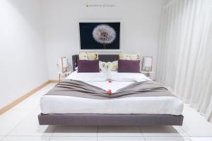 a bedroom with a large bed with purple pillows at Latitude - with private plunge pool in Rivière Noire