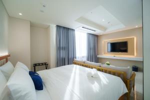 a hotel room with a bed and a flat screen tv at The First Clark Hotel and Residence in Pampang