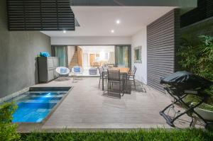 a patio with a pool and a table and chairs at Latitude - with private plunge pool in Rivière Noire
