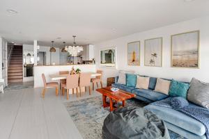 a living room with a blue couch and a table at Malibu Beachfront Home with Rock Spa Ocean Views & Huge Deck in Malibu