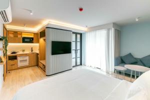 a living room with a bed and a tv and a couch at The SACHA Apart-Hotel Thonglor Sukhumvit Bangkok in Bangkok