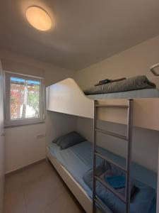 two bunk beds in a room with a window at Holiday Park Mimoza in Bašanija
