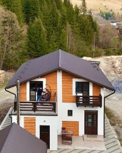 a man standing on the balcony of a house at Cabana LaMunte in Dorna Arini