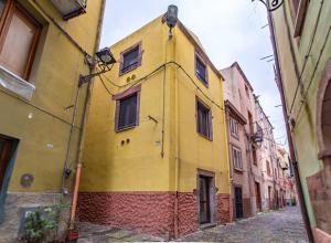 a yellow building on the side of a street at Sardinian Gallery S'Iscola in Bosa