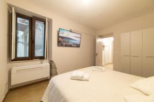 a bedroom with a white bed and a window at Sardinian Gallery S'Iscola in Bosa +4 photos