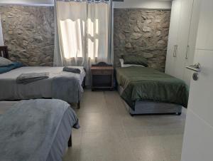a bedroom with two beds and a window and a door at Potjesberg Lodge in Laudina