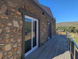 a wooden deck next to a stone building at Potjesberg Lodge in Laudina