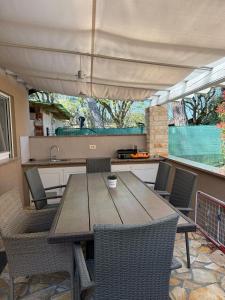 a table and chairs in a kitchen with an umbrella at Holiday Park Mimoza in Bašanija