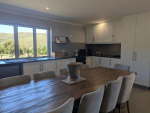 a kitchen with a large wooden table and chairs at Potjesberg Lodge in Laudina