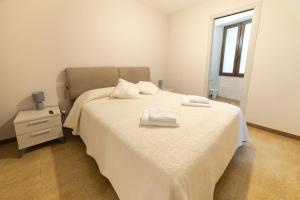 a bedroom with a bed with two towels on it at Sardinian Gallery S'Iscola in Bosa