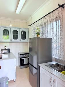 a kitchen with a stainless steel refrigerator and white cabinets at Lumora Homes in Arusha