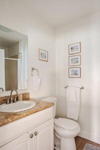a white bathroom with a toilet and a sink at Malibu Beachfront Home with Rock Spa Ocean Views & Huge Deck in Malibu +56 photos