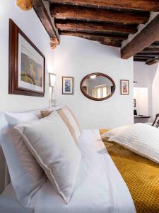 a bedroom with a bed with white pillows and a mirror at Casa Alberi in Volterra