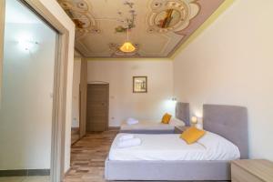 two beds in a room with a ceiling at Sardinian Gallery Sa Funtana in Bosa +9 photos