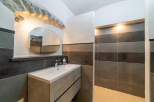 a bathroom with a sink and a mirror at Sardinian Gallery Sa Funtana in Bosa
