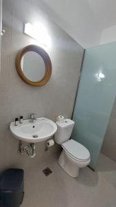 a bathroom with a toilet and a sink and a mirror at Pergola Hotel in Agios Nikolaos +64 photos