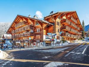 a large wooden building with balconies on a street at Apartment Daphné A 32 by Interhome in Villars-sur-Ollon