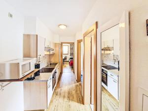 a kitchen with white cabinets and a wooden floor at Apartment Handle-3 by Interhome in Ried im Oberinntal