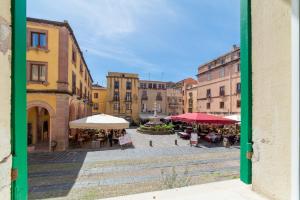 a view of a city street with tables and umbrellas at Sardinian Gallery Sa Funtana in Bosa