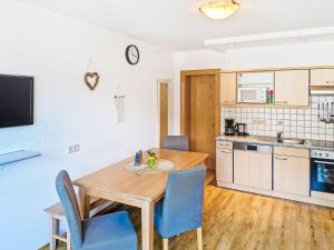 a kitchen and dining room with a wooden table and chairs at Apartment Handle-2 by Interhome in Ried im Oberinntal