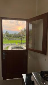 a window in a kitchen with a view of a field at Green Corner VILLA in Bukit Lawang +61 photos