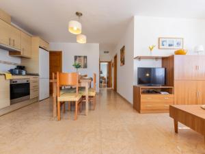 a kitchen and dining room with a table and a television at Holiday Home Flamenc 1 by Interhome in Riumar