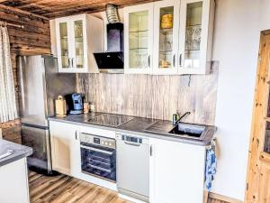 a kitchen with white cabinets and a sink at Chalet Willegger by Interhome in Hochrindl