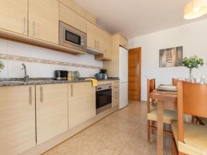 a kitchen with wooden cabinets and a wooden table at Holiday Home Flamenc 1 by Interhome in Riumar +15 photos