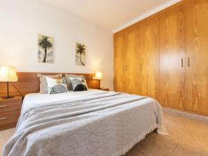 a bedroom with a large bed and wooden cabinets at Holiday Home Flamenc 2 by Interhome in Riumar