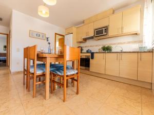 a kitchen with wooden cabinets and a table and chairs at Holiday Home Flamenc 2 by Interhome in Riumar