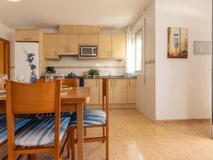 a kitchen with a wooden table and a dining room at Holiday Home Flamenc 2 by Interhome in Riumar +17 photos