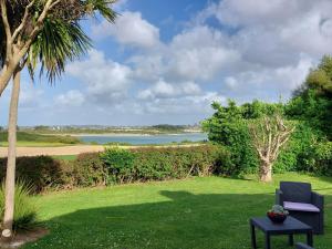 a blue chair on a lawn with a view of the ocean at Holiday Home Ty Nevez by Interhome in Sibiril