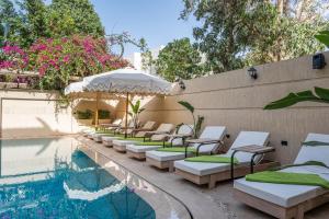 a row of chaise lounge chairs next to a swimming pool at Sam's Story Boutique Hotel in Cairo