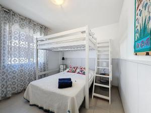 a white bedroom with a bunk bed and a ladder at Apartment Pattaya-8 by Interhome in Empuriabrava