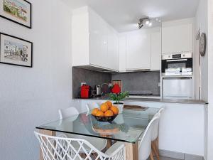 a kitchen with a glass table and white cabinets at Apartment Pattaya-8 by Interhome in Empuriabrava