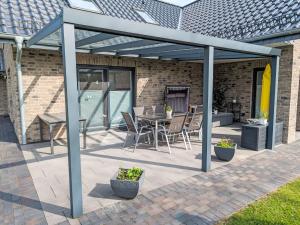 a pergola with a table and chairs on a patio at Holiday Home Sonnenschein by Interhome in Wanna