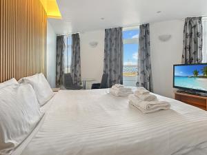 a hotel room with a bed with towels on it at Granada Apartments Queens Mansions in Blackpool +290 photos