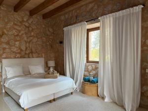 a bedroom with a white bed and a window at Finca Latenéa in Islas Baleares