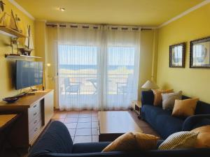 a living room with a blue couch and a television at Apartment Port Pals Summer Vibes by Interhome in Pals