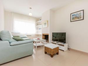 a living room with a couch and a television at Holiday Home Canyadell by Interhome in Torredembarra +22 photos