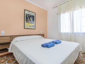 a bedroom with a bed with two blue objects on it at Villa Villa Maire by Interhome in Miami Platja +18 photos