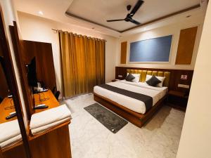 a hotel room with a bed and a television at Hotel shivay palace in Rishīkesh +47 photos