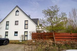 a white house with a wooden fence in front of it at Ferienwohnung Schultz in Zinnowitz