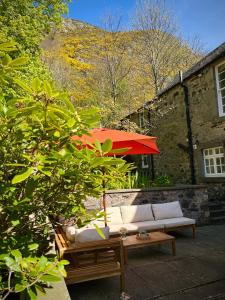a couch and a table and a red umbrella at The Coach House in Stirling