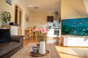 a vase with pink flowers on a table in a living room at Ferienwohnung Schultz in Zinnowitz