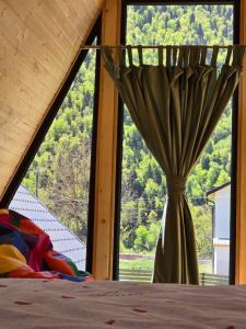 a vase sitting next to a window with a curtain at Borjomi Hills in Borjomi